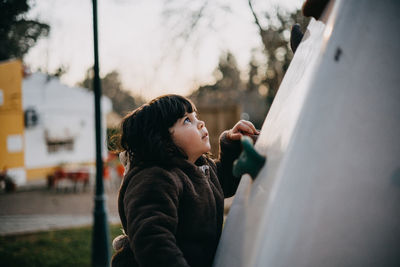 Cute girl climbing wall in playground