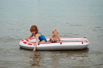 Siblings in boat on sea