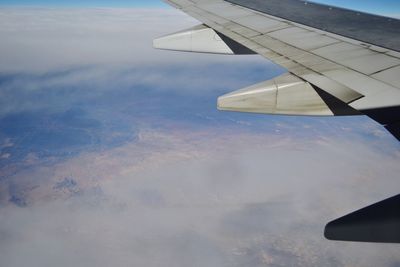 Airplane flying over landscape against sky