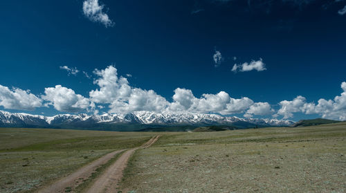 Scenic view of road amidst mountains against sky