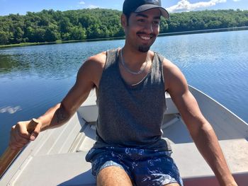 Portrait of smiling young man in boat sailing on river