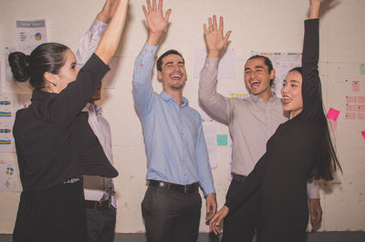 Colleagues giving high-five in office during meeting