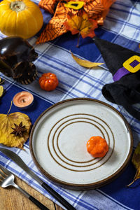 Halloween day decoration party, halloween festive table setting with pumpkins and autumn leaves.