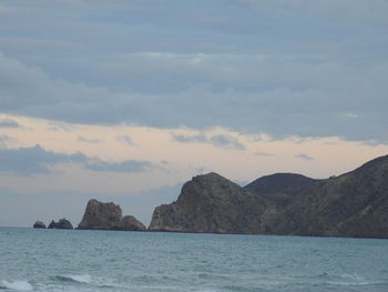 Scenic view of sea and mountains against sky