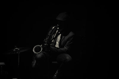 Midsection of man playing guitar at night