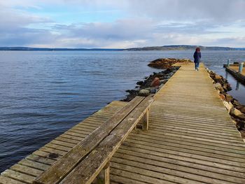 A woman walking on a wooden pier - lysaker