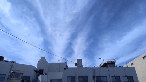 Low angle view of buildings against cloudy sky