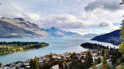 Scenic view of river amidst mountains against cloudy sky