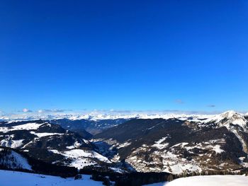 Scenic view of snowcapped mountains against clear blue sky