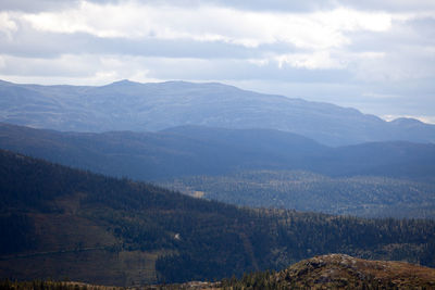 Scenic view of mountains against cloudy sky