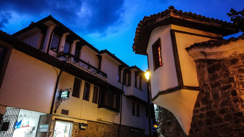 Low angle view of illuminated building against sky at dusk