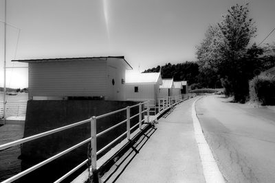 Road by buildings in city against sky