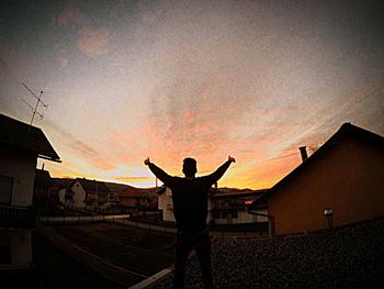 Silhouette of man on cross against sky