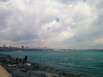 Scenic view of sea and cityscape against sky