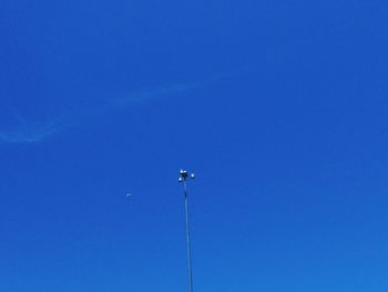 Low angle view of bird flying against clear blue sky