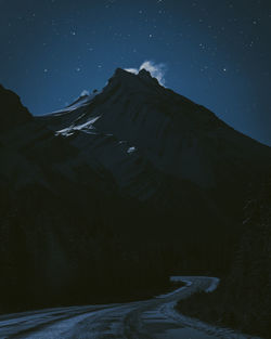 Scenic view of snowcapped mountains against sky at night
