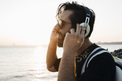 Portrait of young man wearing sunglasses against sky