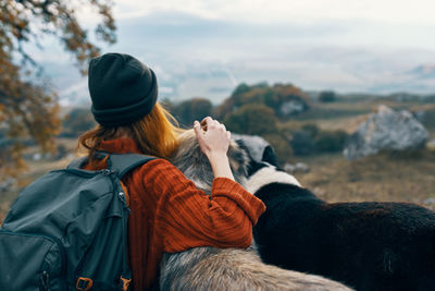 Rear view of woman with horse in background