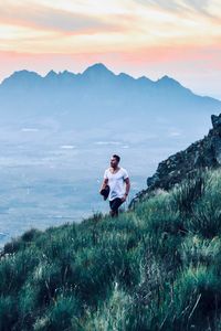 Full length of man standing on land against sky during sunset