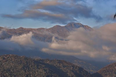 Scenic view of mountains against cloudy sky