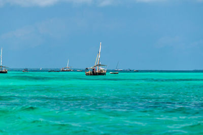 Sailboats sailing on sea against sky