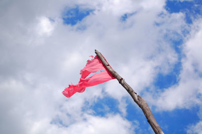 Low angle view of red flag against sky