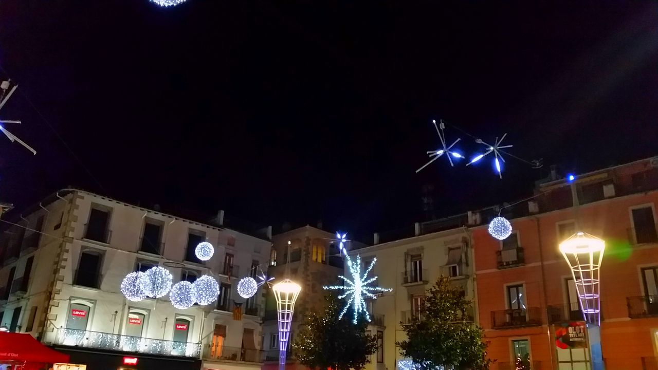 LOW ANGLE VIEW OF ILLUMINATED BUILDING AT NIGHT