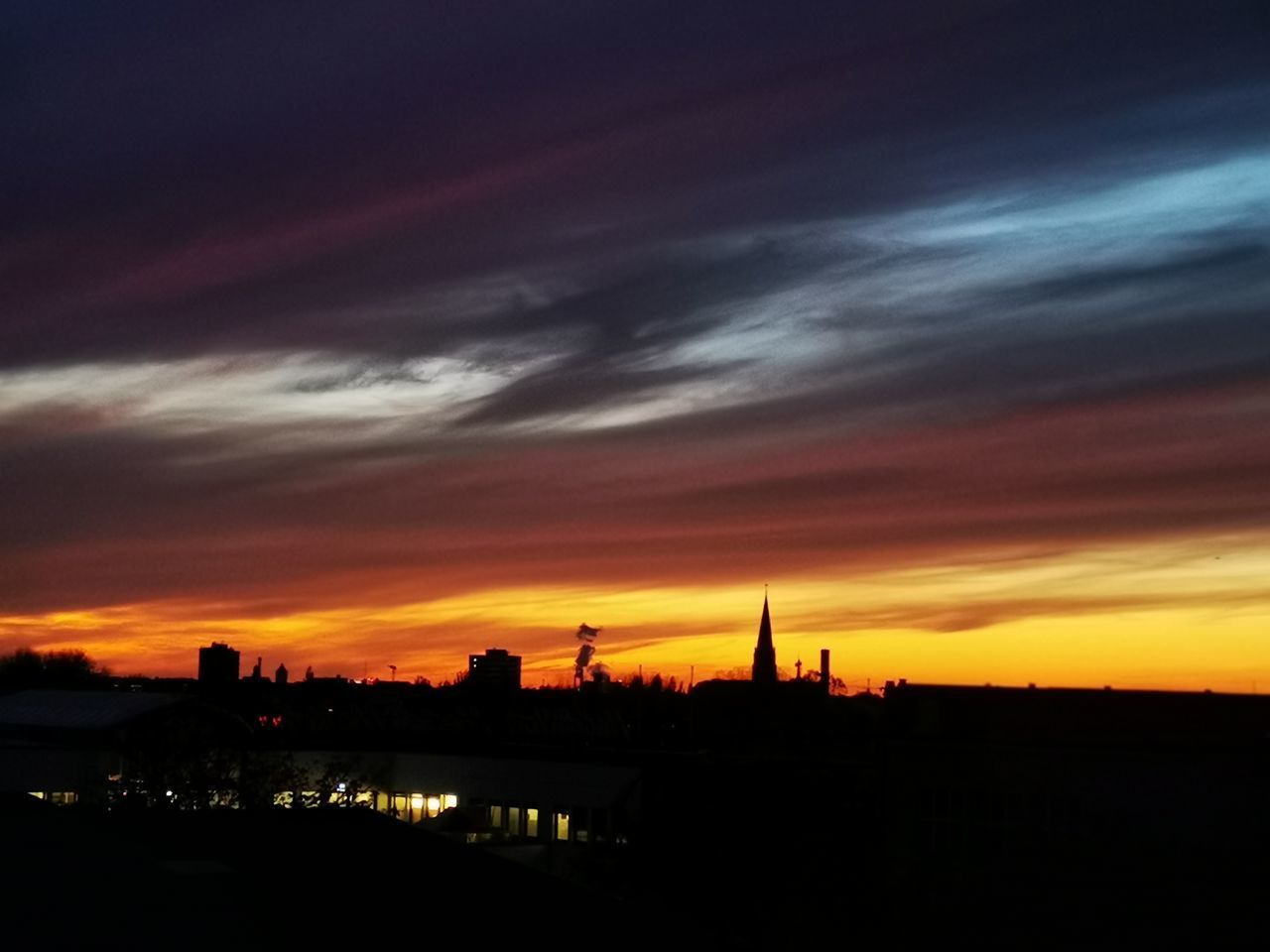 SILHOUETTE OF BUILDINGS AGAINST DRAMATIC SKY