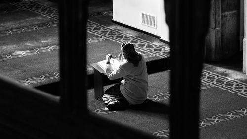 Rear view of man sitting by window