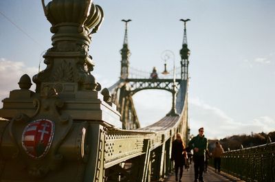 People walking on bridge against sky