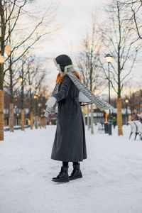 Rear view of woman standing in snow