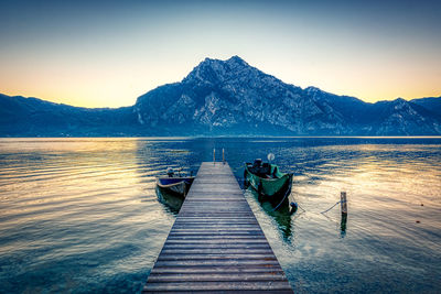 Pier over lake against clear sky