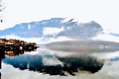 Scenic view of lake by buildings against sky