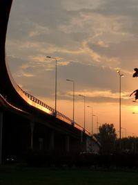 Street lights against orange sky