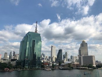 Buildings in city against cloudy sky