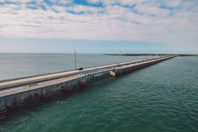 Pier over sea against sky during sunset