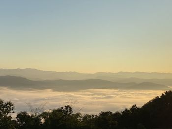 Scenic view of silhouette mountains against clear sky at sunset