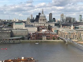 Bridge over river against buildings in city