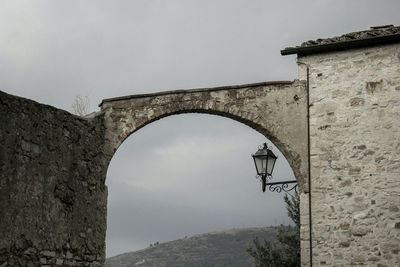 Low angle view of bridge over mountain against clear sky