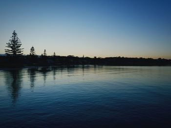 Scenic view of lake against clear sky during sunset