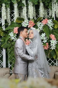 Young couple standing by flowering plants