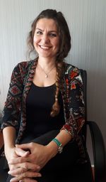 Portrait of smiling woman on chair against wall