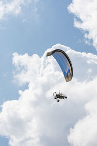 Low angle view of person paragliding against sky