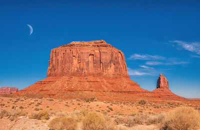 Rock formations on landscape against blue sky