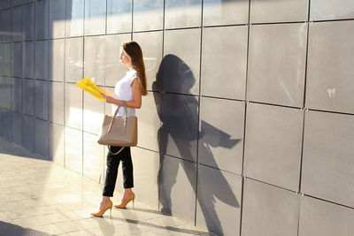 Woman with umbrella walking on floor in building