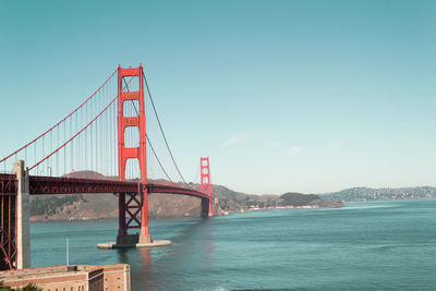 Golden gate bridge over sea against sky during sunny day