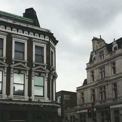 Low angle view of buildings against cloudy sky