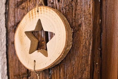 Close-up of star shape carved wood hanging by wall