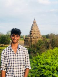 Portrait of young man standing against temple