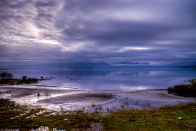 Scenic view of beach against dramatic sky